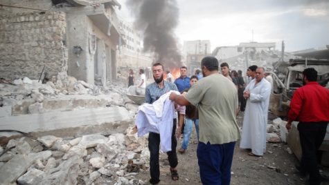 Syrian citizens are seen leaving the aftermath of a fire.