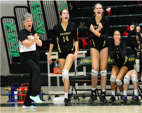 During a game (pictured left to right) Coach Shifflett, Hannah Curtis, Allison Franke, and Jessica Maebius cheer for the Saxons.  Langley’s varsity team went 27-3 including preseason and playoffs.  Photo courtesy of Coach Shifflett.