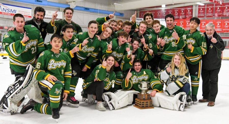 Langley Hockey Team celebrating their win with their coaches and their newly received championship cup.  