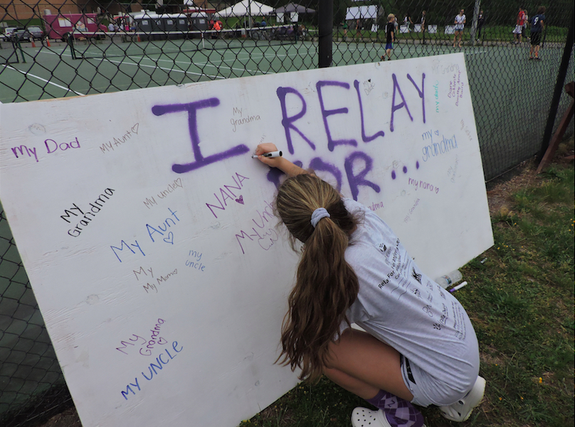 A Langley student signs the Relay for Life "I Relay For..." board.