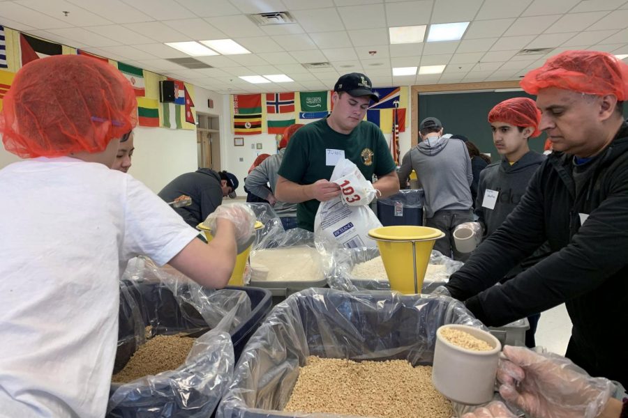 Senior John Callahan works with others to complete his service hours during the monthly Saxon Service time (Photo by Chen). 