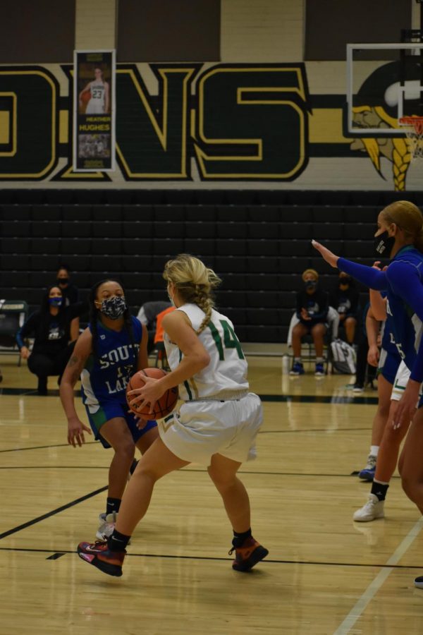 Senior Summer Thomas (#14) takes possession of  the ball during the intense game. Even with a tough fight, Langley lost by three points.