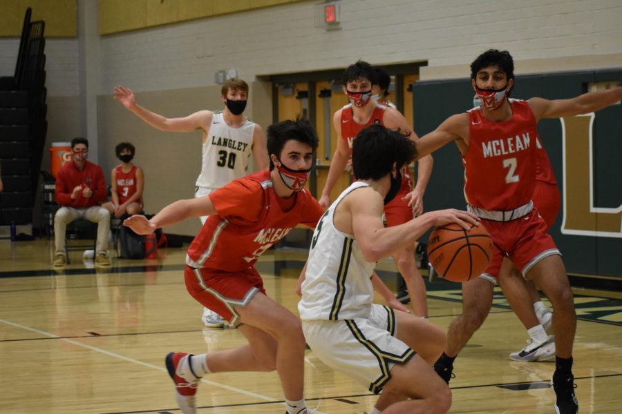 Sophomore Brendan Mansinne (#5) keeps the ball in Langleys possession while on offense. The Saxons were able to make a major comeback with their baskets in the second half.